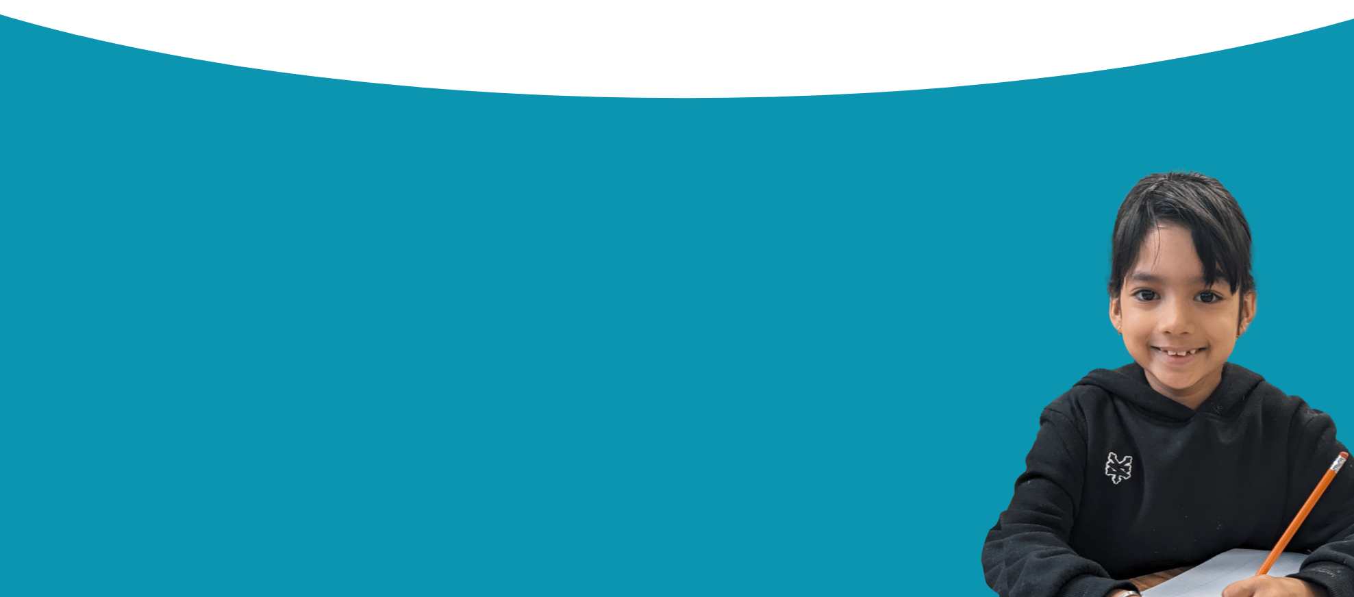 Photo of a LiftED program participant writing on a piece of paper and smiling at the camera